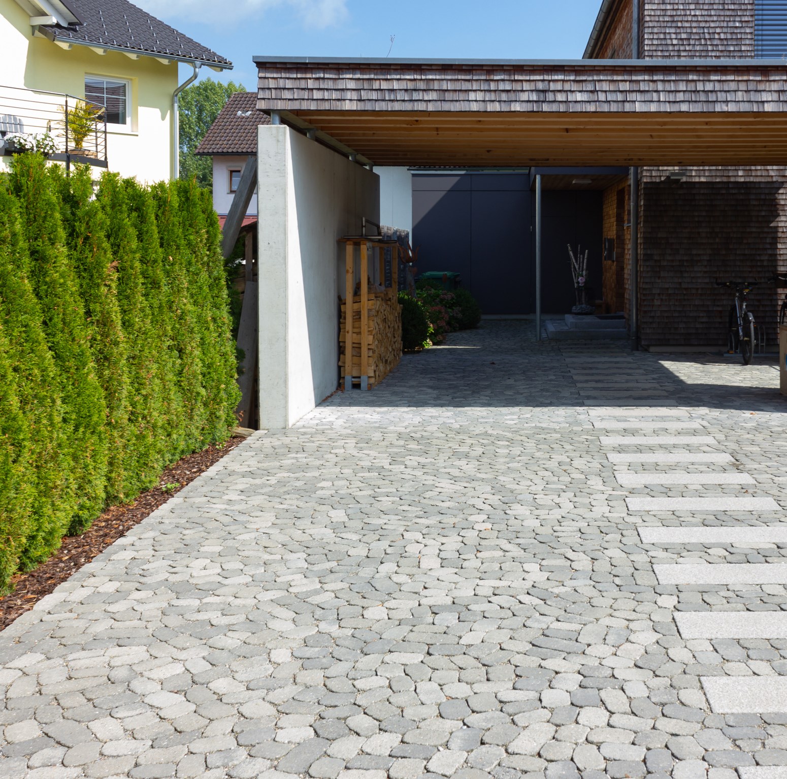 Carport in Hauseinfahrt mit Pflasterung
